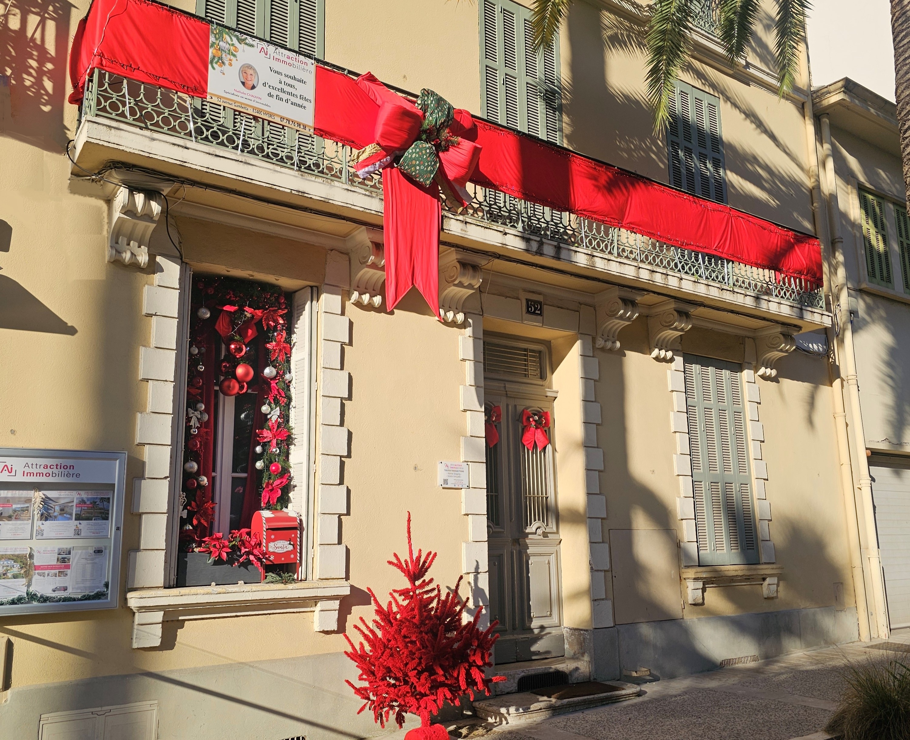 Façade décorée de l'agence Attraction Immobilière à Hyères pour Noël avec boîte aux lettres magique.